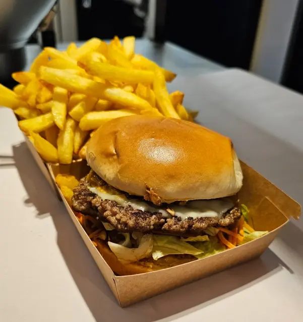 Smashburger premium MDjambo dans restaurant avec ambiance chaleureuse orange
